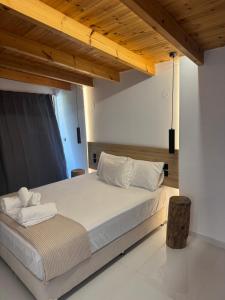 a bedroom with a large bed with a wooden ceiling at 44 suites Lygia in Paralia Vrachou