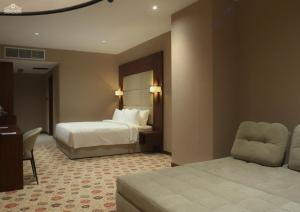 a hotel room with two beds and a desk and a chair at Bilitom Hotel in Baghdād +48 photos