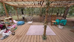 a wooden deck with a gazebo with a rug at Gite de la grande Ourse in Reignac