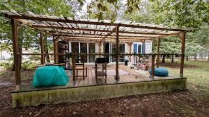 a pergola with a table and chairs on a deck at Gite de la grande Ourse in Reignac