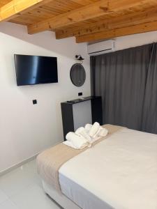 a bedroom with a bed with towels on it at 44 suites Lygia in Paralia Vrachou