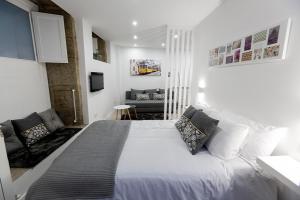 サンティアゴ・デ・コンポステーラにあるApartamentos Pombalのベッドルーム(大型ベッド1台、ソファ付)