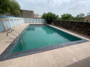ein Swimmingpool mit grünem Wasser auf einer Terrasse in der Unterkunft KothiPushkar in Pushkar