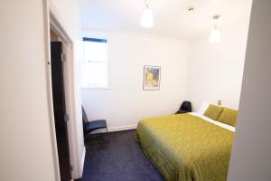 a small room with a bed and a window at Chapel Apartments in Dunedin