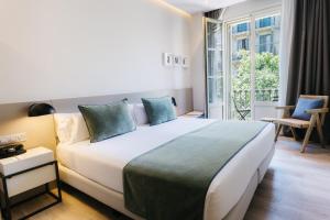 a bedroom with a large white bed with blue pillows at Hotel Well and Come Barcelona in Barcelona +72 photos