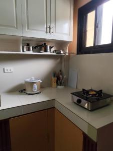 a kitchen with a stove and a counter top at Balancia Guest House 3F unit 5 in Baguio