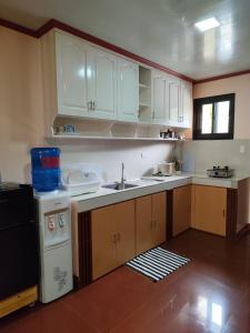 a kitchen with white cabinets and a sink at Balancia Guest House 3F unit 5 in Baguio