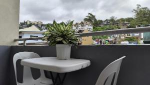 a white table and chair on a balcony with a plant at Balancia Guest House 3F unit 5 in Baguio +6 photos