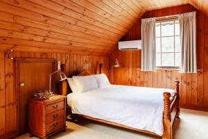 a bedroom with a large bed and a window at The Cottage at Paramoor Winery in Carlsruhe