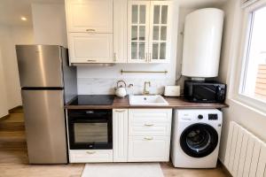 a kitchen with a refrigerator and a washing machine at La Suite Prestige in Château-Thierry +6 photos
