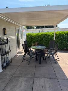 a patio with a table and chairs under a canopy at Chalet SEASIDE in Lathum