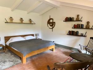 a bedroom with a bed and two chairs and shelves at Vista Romena in Pratovecchio