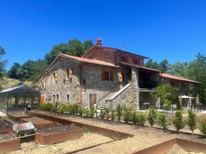 an old stone building with a garden in front of it at Vista Romena in Pratovecchio