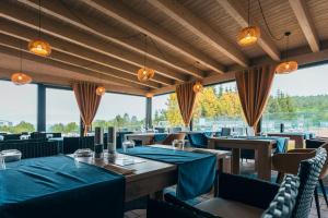 a restaurant with blue tables and chairs and windows at Hotel Mauricius in Příbram
