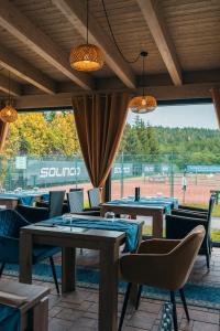 a restaurant with tables and chairs and a baseball field at Hotel Mauricius in Příbram