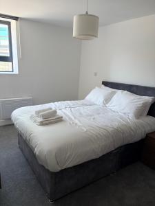 a bedroom with a bed with two towels on it at Broadway residence G01 in Bradford