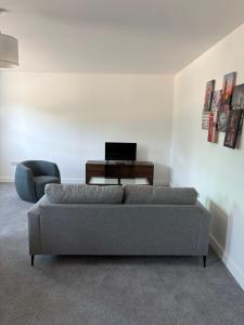 a living room with a couch and a laptop on a table at Broadway residence G01 in Bradford