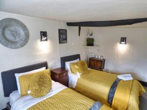 a bedroom with two beds with yellow and white sheets at Ye Olde Red Horse in Evesham