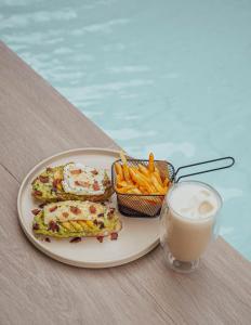a plate with a sandwich and french fries and a drink at KHAMI HOUSE Resort in Panglao Island