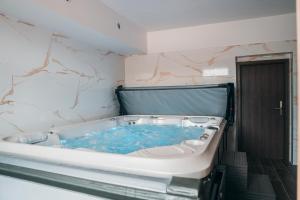 a bath tub with blue water in a bathroom at Hotel Mauricius in Příbram +52 photos