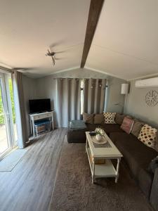 a living room with a couch and a table at Chalet SEASIDE in Lathum
