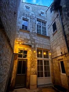 an old stone building with two doors and lights at Le Notre Dame - Hyper centre in Angoulême