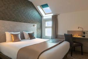a hotel room with a large bed and a desk at The Originals City, Hôtel Orléans Nord in Saran +33 photos