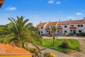 a row of buildings with palm trees in the foreground at Azeitão Town House in Azeitao