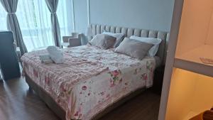 a bedroom with a bed with a floral blanket and pillows at wyndham panbil sanctuary in Kangboi +22 photos