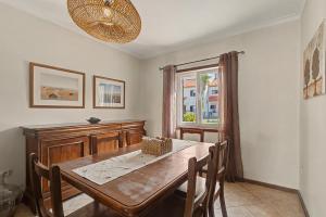 a dining room with a wooden table and a window at Azeitão Town House in Azeitao