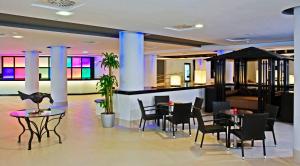 a lobby with tables and chairs and a bar at SOL by Meliá Guadalupe in Magaluf