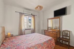a bedroom with a bed and a dresser and a television at Azeitão Town House in Azeitao