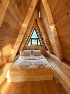 a bed in a wooden room with a window at Jugoslavija Chalet and Spa Zabljak in Tepačko Polje