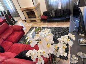 a living room with a red couch and white flowers at !Chalet de lujo para vacaciones!... in Camargo