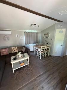 a living room with a couch and a table at Chalet SEASIDE in Lathum