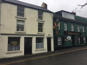 a green and white building on the side of a street at Roomz in Portaferry