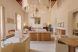 a living room with white furniture and a fireplace at Fontsanta Hotel Thermal & Spa - Adults Only in Colònia de Sant Jordi