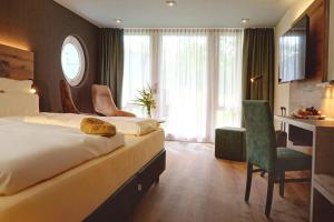a hotel room with two beds and a desk at Das Allgäu in Maierhöfen +39 photos
