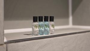 two bottles of alcohol sitting on a shelf in a bathroom at No32 Hotel in Edinburgh +82 photos