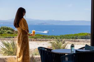 a woman in a dress is looking out at the ocean at Santateresa in Bonifacio