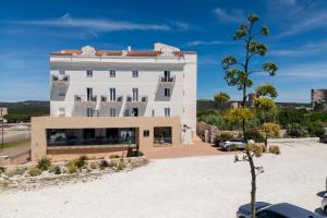 a large white building with a parking lot at Santateresa in Bonifacio