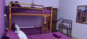 a bedroom with two bunk beds with purple sheets at East Breeze in Arugam Bay