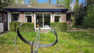 a house with a pair of horns in the yard at Huisje Piet in Hoenderloo