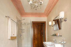 a bathroom with a chandelier and a sink and a shower at Palazzo Benassi Nobile Dimora nel Cuore di Asolo in Asolo