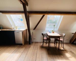 a kitchen with a table and chairs in a attic at De Lotuspoort met Mihr's rustplek in de Abdij van Bornem in Bornem +70 photos