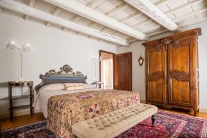 a bedroom with a bed and a wooden cabinet at Palazzo Benassi Nobile Dimora nel Cuore di Asolo in Asolo