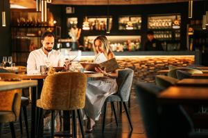 a man and woman sitting at a table in a restaurant at Domaine Sur Les Sarts in Ohey