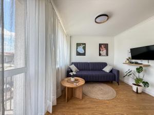 a living room with a blue couch and a table at Apartament Biłgorajski przy Rynku in Biłgoraj