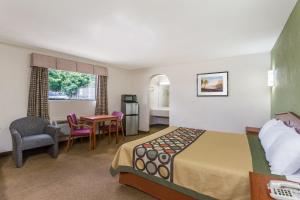 Knights Inn Franklin Ave Waco في واكو: غرفة فندقية بسرير وطاولة وكراسي