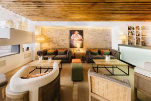 a living room with a couch and tables at Hotel Well and Come Barcelona in Barcelona